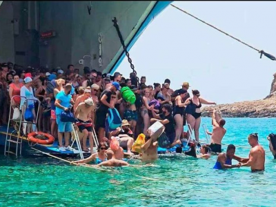 A Creta niente molo, turisti costretti a entrare in acqua con i bagagli sulla testa  per sbarcare o salire a bordo dei traghetti – Il video 