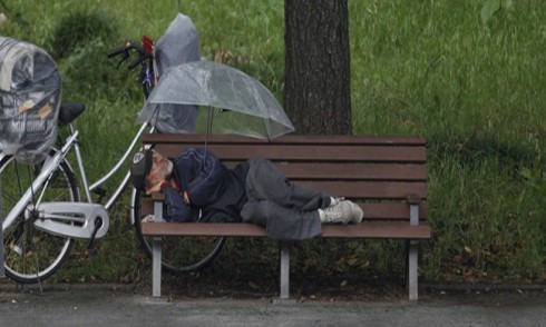 pensionato che dorme su una panchina